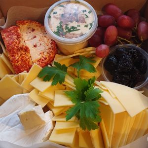 A box containing a selection of cheeses and dips