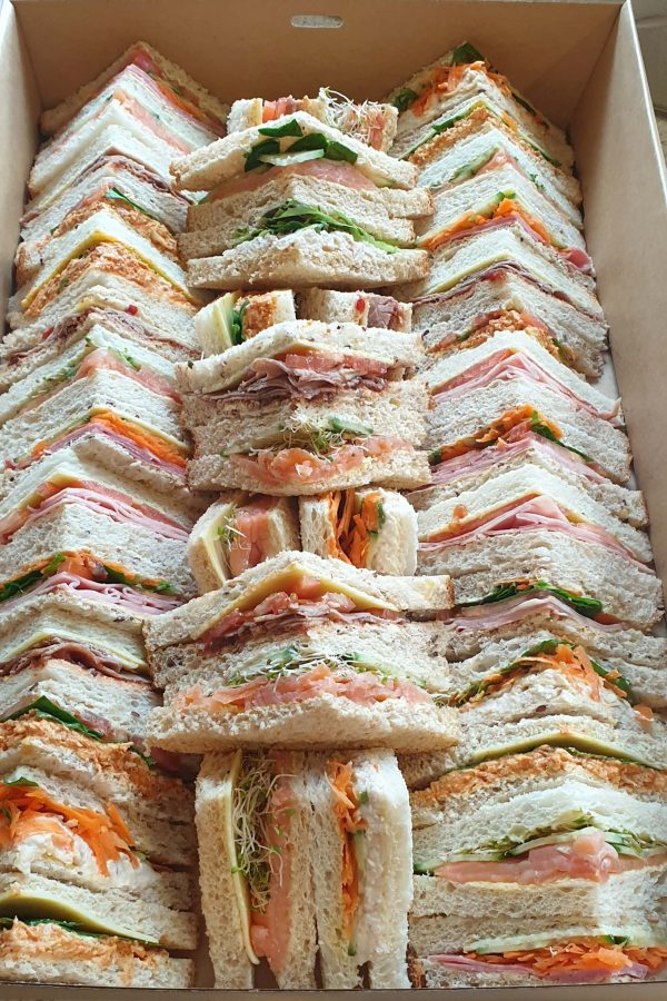 A box containing a large quantity of triangle cut sandwiches